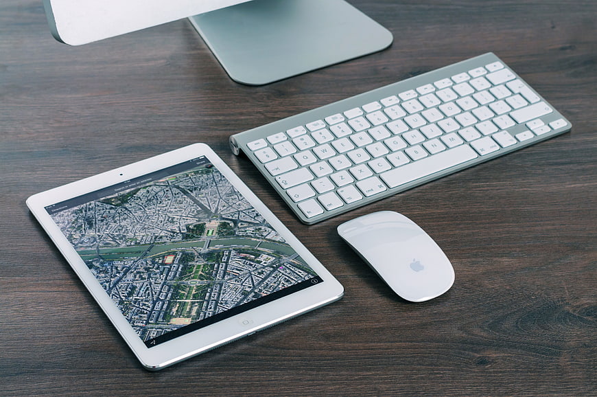 Modern workspace with tablet, keyboard, and mouse on wooden desk