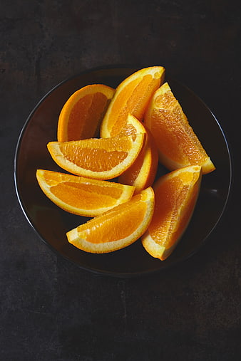 Fresh Sliced Oranges on Dark Plate Top View