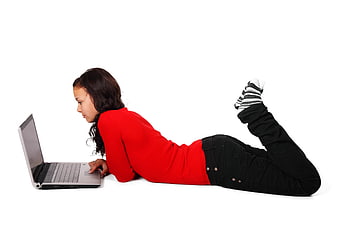 Young woman lying on floor using laptop computer
