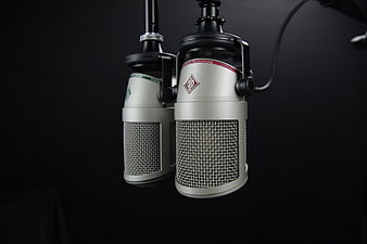 Two Silver Condenser Microphones on Black Background