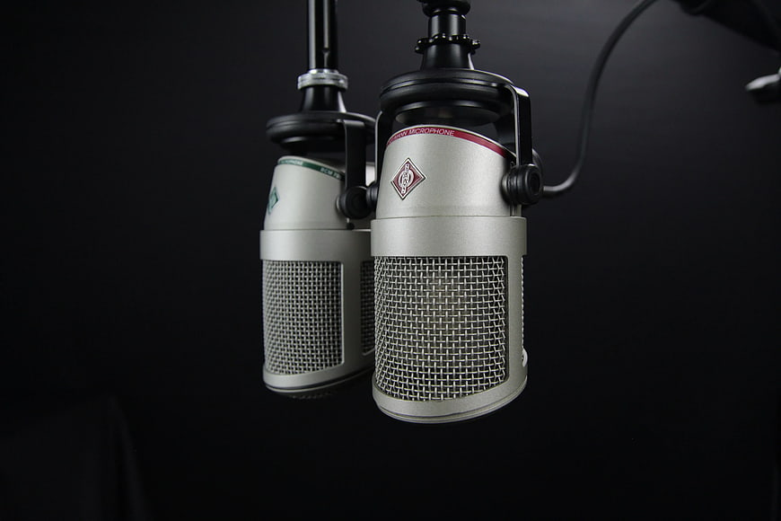 Two Silver Condenser Microphones on Black Background