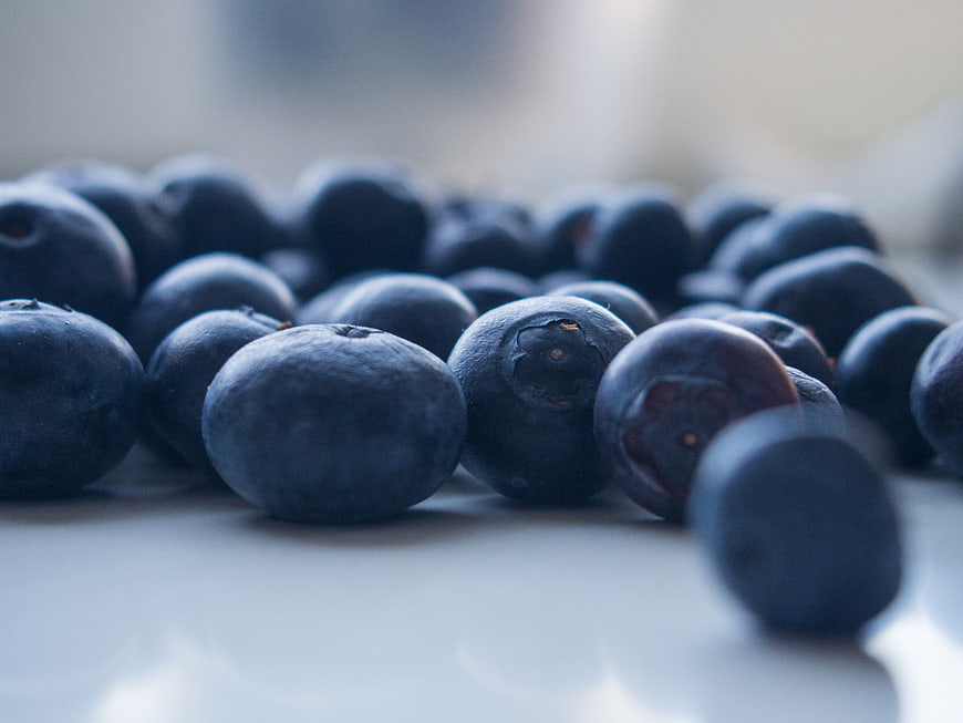Close-up of fresh blueberries on a white surface