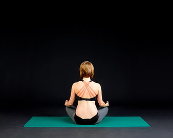 Woman Meditating on Yoga Mat from Behind