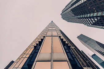 Worm's eye view of modern skyscrapers against overcast sky