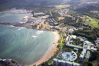 Aerial view of tropical resort, beach, and harbor coastline