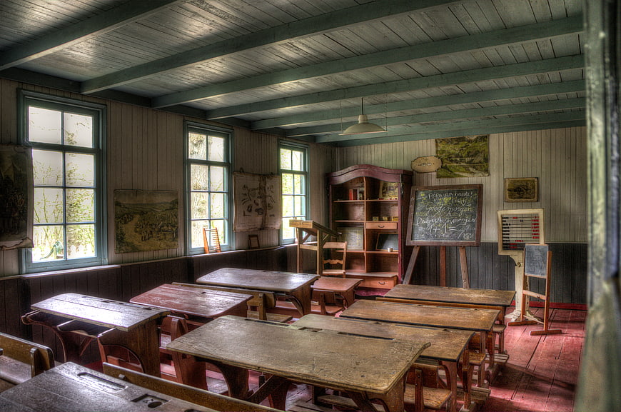 Vintage 1950s Classroom Interior with Wooden Desks and Blackboard
