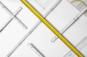 Flat lay of yellow tape measure and rulers on white background