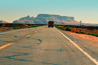 Yellow School Bus Driving on Desert Highway