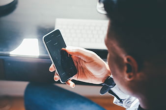 Man Entering PIN Code On Smartphone Screen In Office