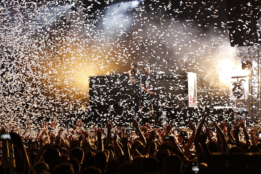 Live concert crowd with confetti and stage lights