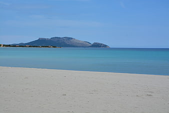 Serene Sardinian Beach with Turquoise Sea and Distant Mountains
