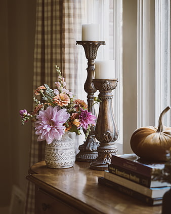 Cozy autumn home decor with flowers, candles, and books