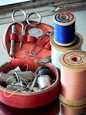 Vintage sewing kit with thimbles, scissors, and colorful thread spools