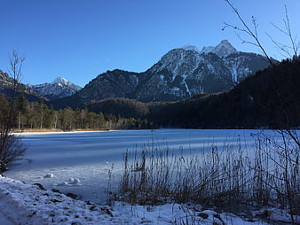 Frozen Lake with Snow-Capped Mountains in Winter Landscape