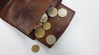 Brown leather wallet with euro coins on white background