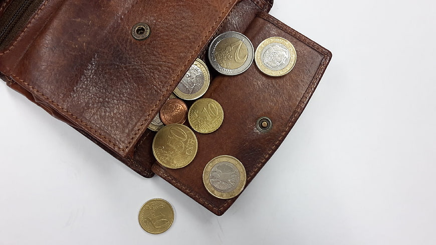 Brown leather wallet with euro coins on white background