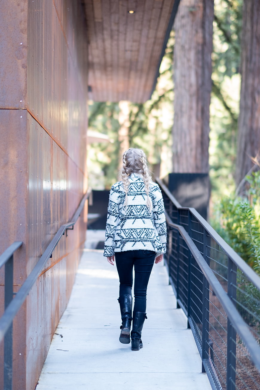 Woman with braids walking away on outdoor path