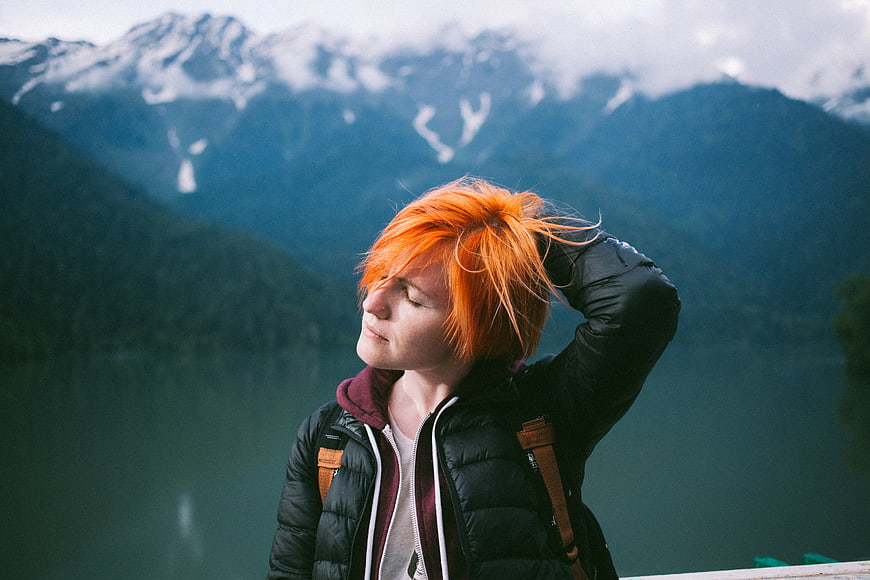 Woman with Orange Hair Enjoying Mountain Lake View