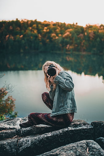 Female Photographer Taking Pictures by Lake in Autumn