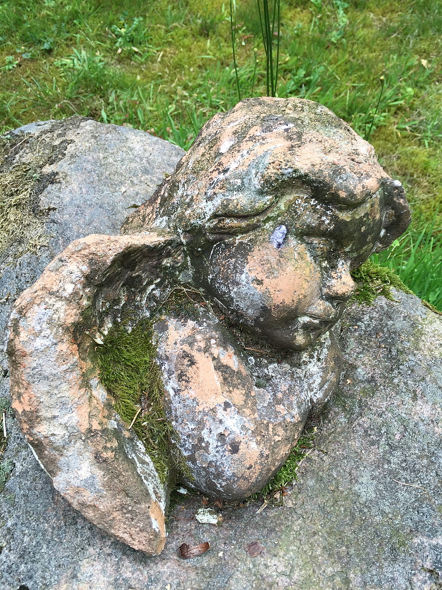 Weathered Stone Angel Sculpture in Garden