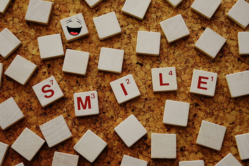 Scrabble tiles spelling smile on cork board background