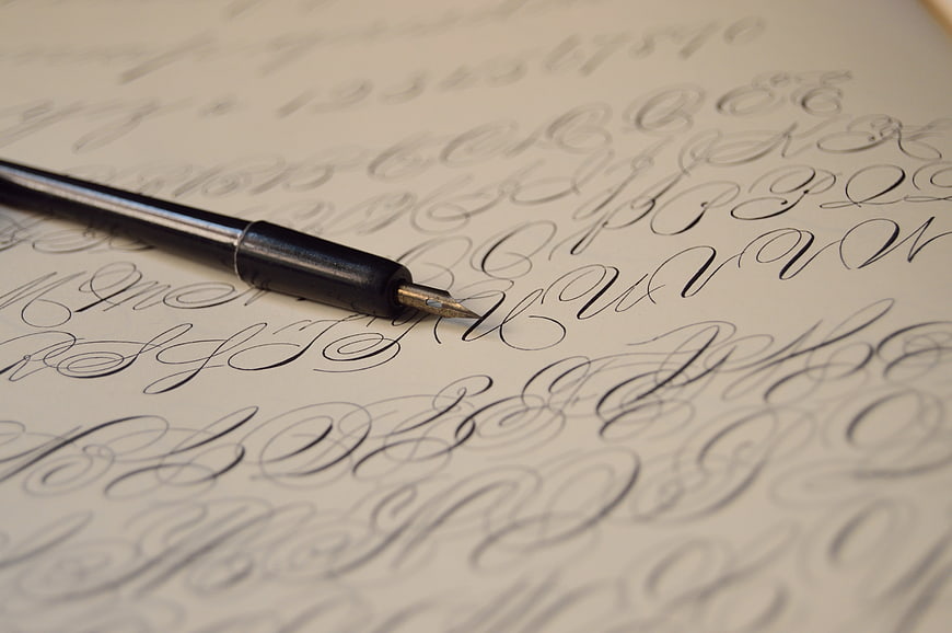 Close-up of fountain pen nib on calligraphy practice sheet