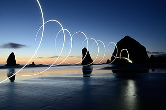 Light Painting Spirals on Beach at Sunset