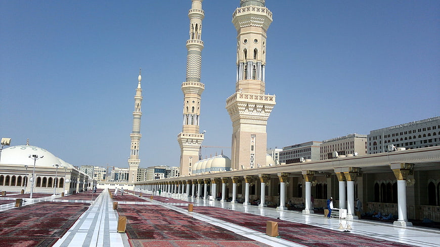 Grand Mosque Courtyard with Minarets and Red Carpets