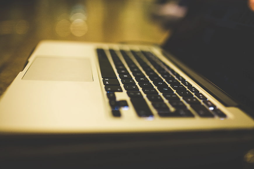 Close-up of silver laptop keyboard with bokeh background