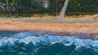 Aerial View of Ocean Waves Crashing on Sandy Beach