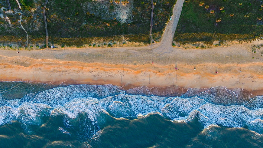 Aerial View of Ocean Waves Crashing on Sandy Beach